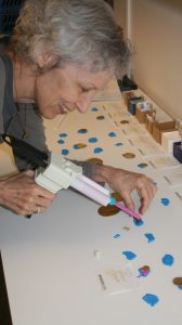 Nancy Wicker works with polyvinyl siloxane to make impressions from broken portions of bracteates.