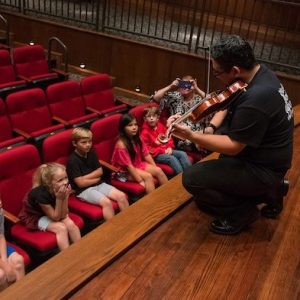 Alex Urbina (right), a UM graduate student and section leader in the LOU Symphony Orchestra, lets Oxford second-graders get a close-up view of his playing during a special presentation of ‘Peter and the Wolf’ at the Ford Center. Photo by Kevin Bain/