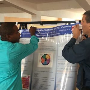 Cuba TIES IV Conference participants help set up one of the posters by UM faculty for presentation.