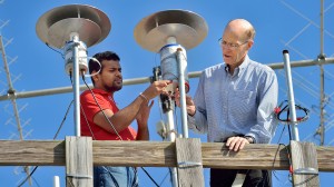 UM physicists Sampath Bandara (left) and Thomas Marshall place a light sensor in place as part of their study of lightning strikes. | Photo by Robert Jordan, UM Communications