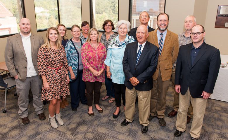Reba Greer (center, in blue) and her husband Lance (to her left) attend a reception in their honor hosted by faculty and staff of the Department of Writing and Rhetoric for which the Greers established an endowment.