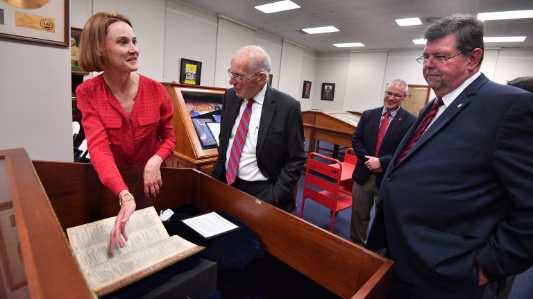 Jennifer Ford shows Shakespeare’s Second Folio to Jesse L. White, Associate Provost Noel Wilkin and Provost Morris Stocks. Photo by Kevin Bain/Ole Miss Communications