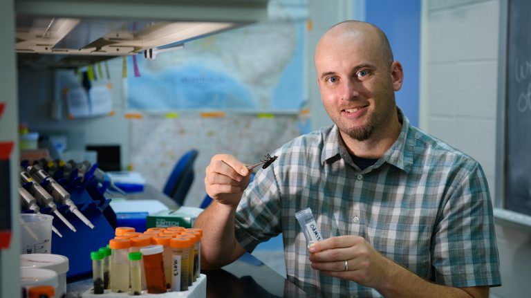 Ryan Garrick, UM assistant professor of biology, examines insects as part of his research on the effects of environmental change. Photo by Robert Jordan/Ole Miss Communications