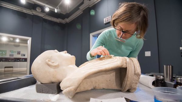 Conservator Amy Jones Abbe gives the Bust of an Unknown Roman a careful cleaning as part of her residency at University Museum. Photo by Kevin Bain/Ole Miss Communications