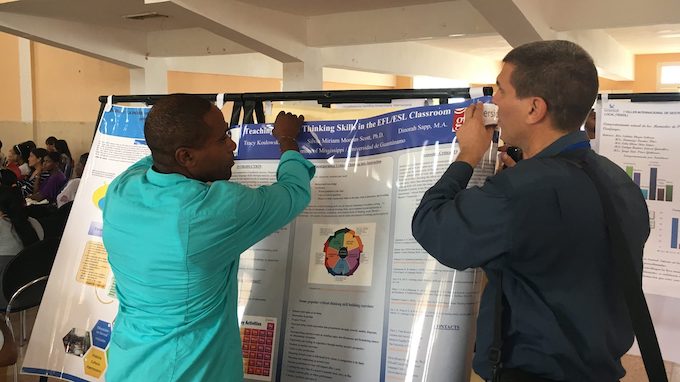 Cuba TIES IV Conference participants help set up one of the posters by UM faculty for presentation.